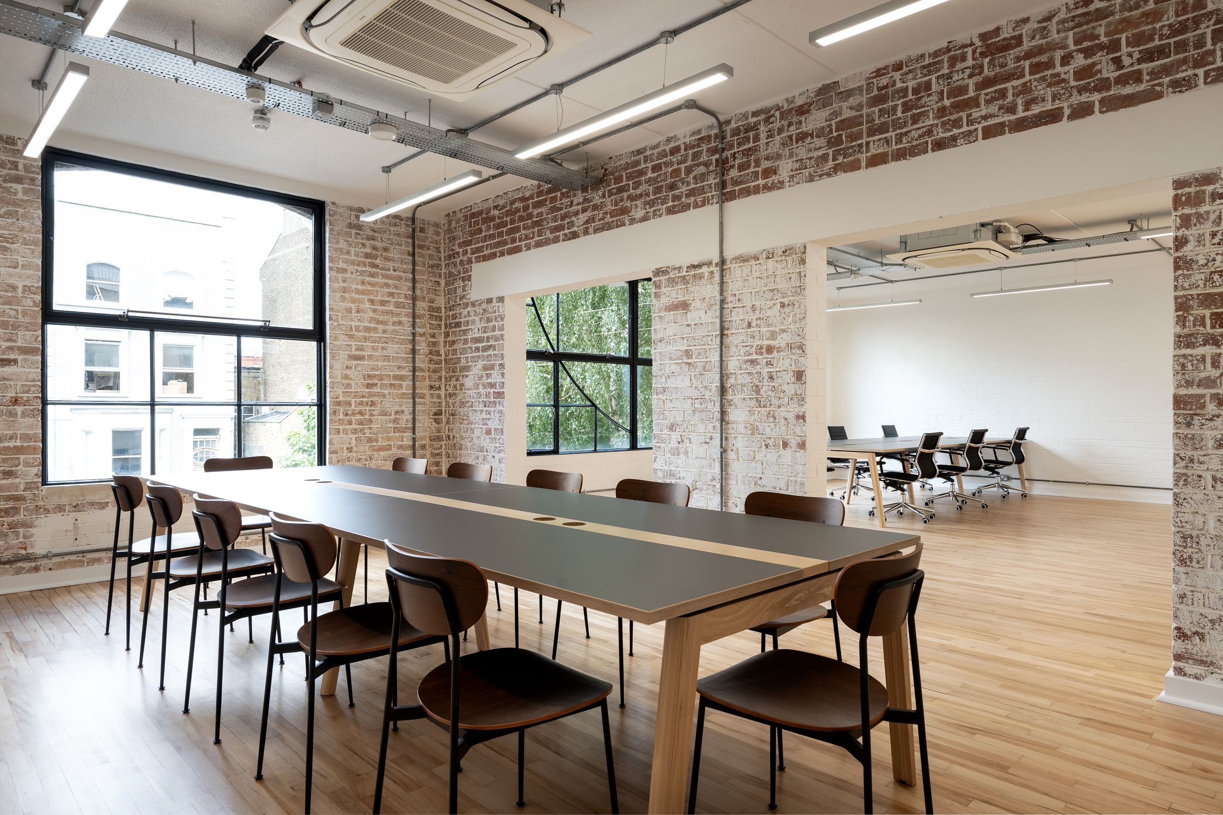Meeting space with exposed brickwork and full-height windows